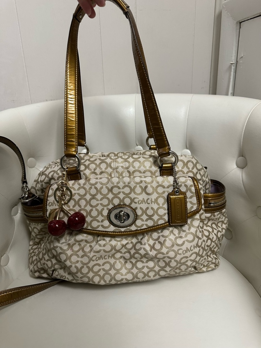 Coach Cream Signature Canvas Shoulder Bag with Metallic Gold Trim and Red Charm